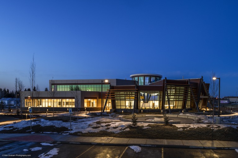 Lit up building with decorative panelling and tiles at night