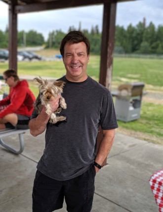 Dave holding Yorkshire terrier in a park