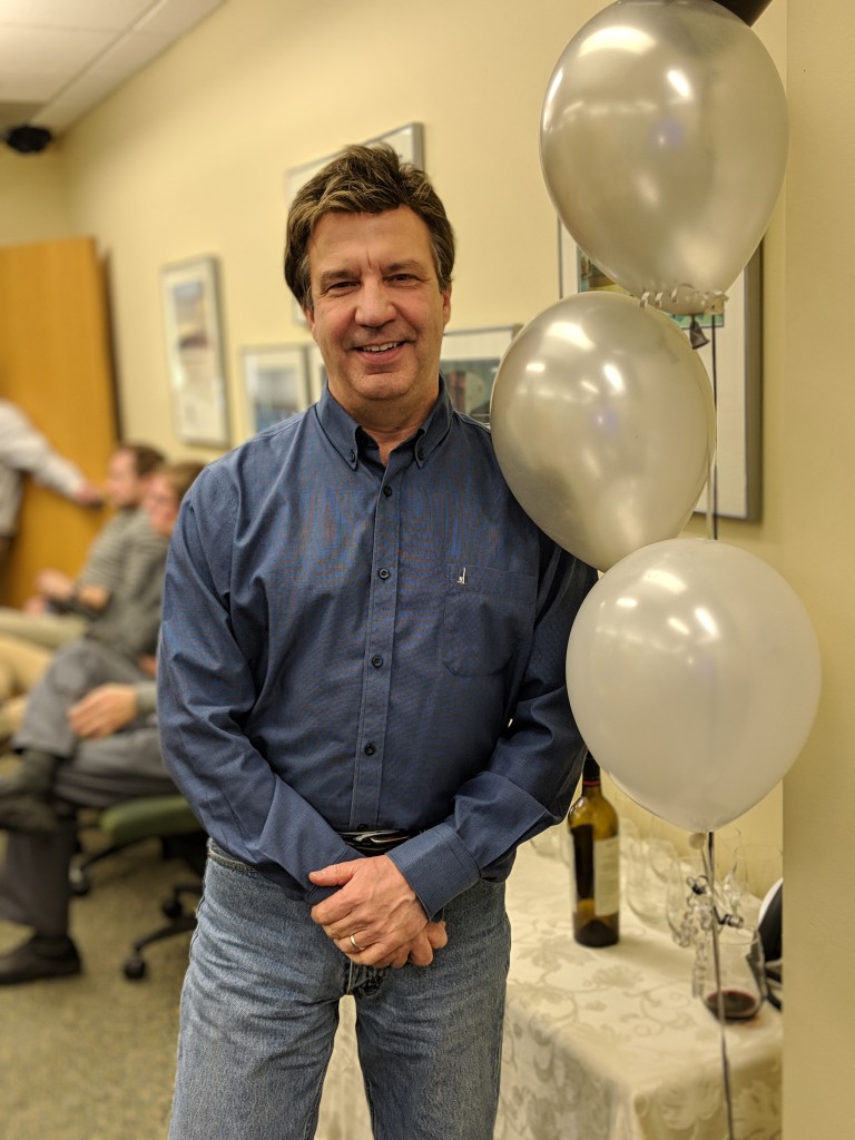 Dave standing near balloons at celebration