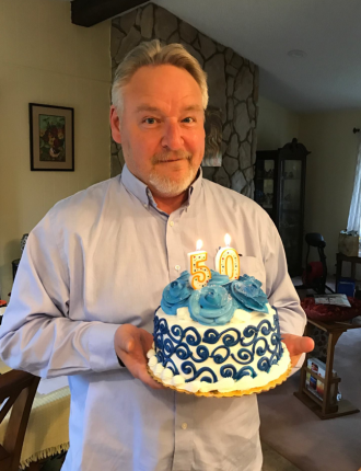 Keith Confer holding cake on his 50th birthday