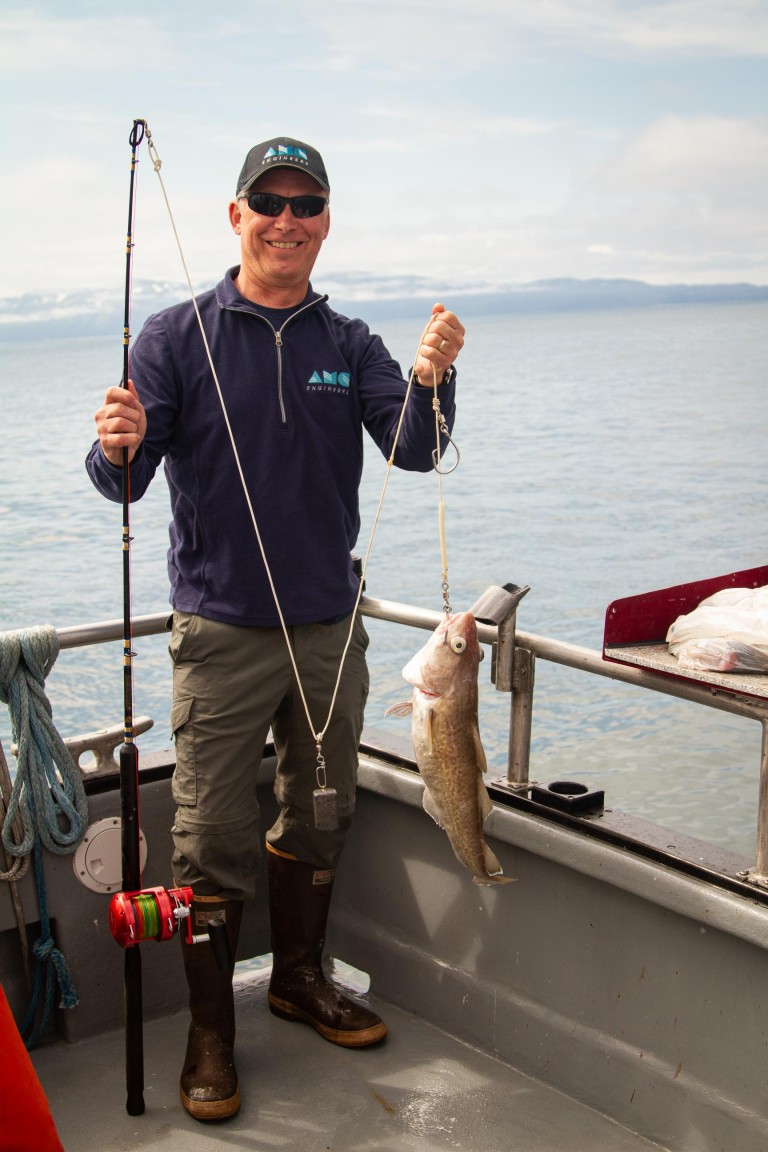 Ken holding a fish on a fishing reel