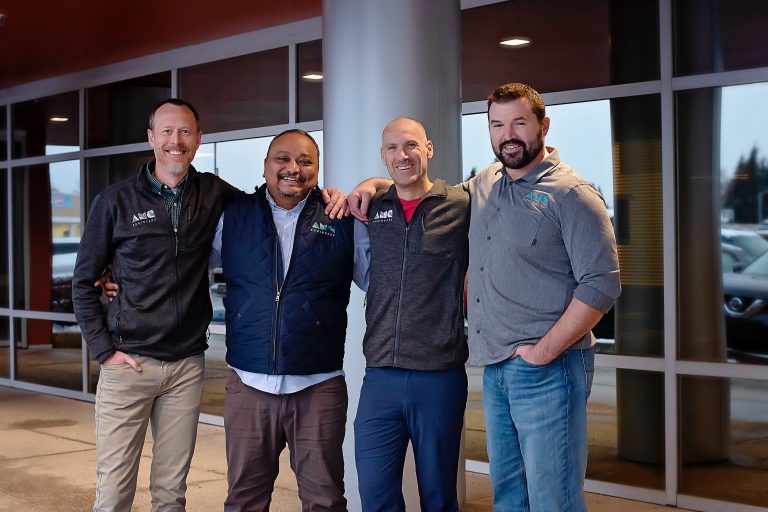 John posing with three other AMC employees