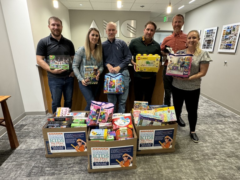 AMC employees holding gifts for a toy drive