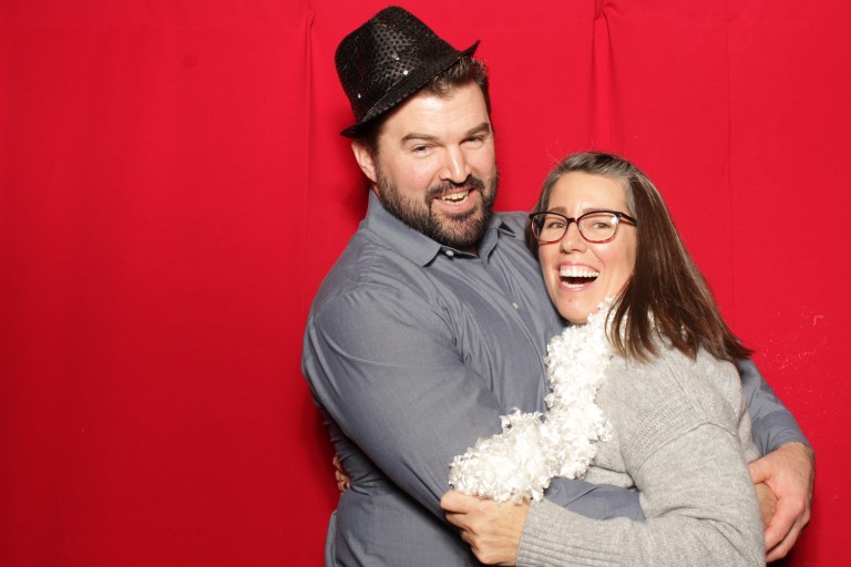 Aaron Jordan standing with a woman in front of a red backdrop