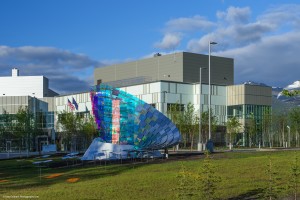 Large multistory building with decorative panelling and large sculpture in front yard