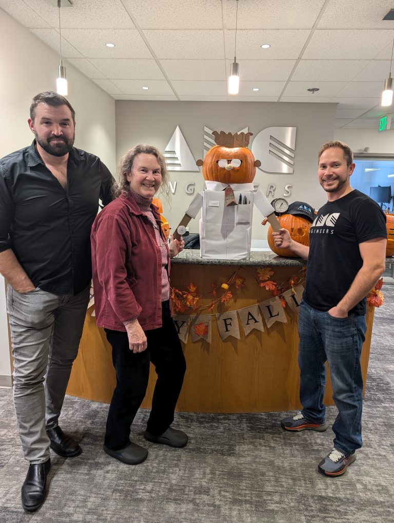 Tami standing in front of a pumpkin sculpture with other AMC employees