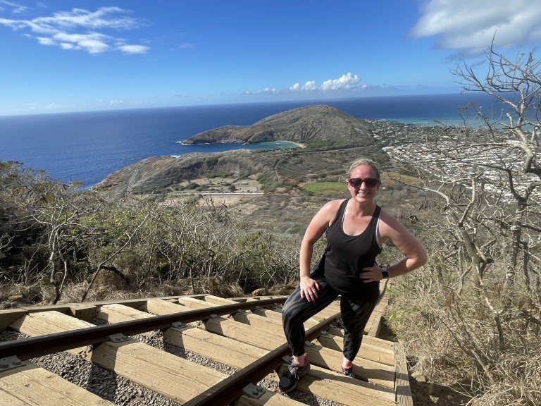 Brittany hiking up a rail on a mountain side