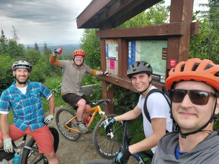 Multiple AMC employees biking on a mountain trail
