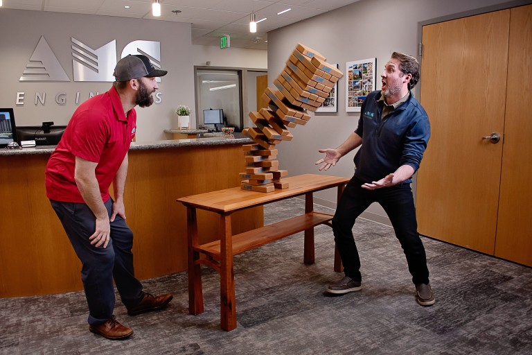 AMC employees look shocked as Jenga tower falls