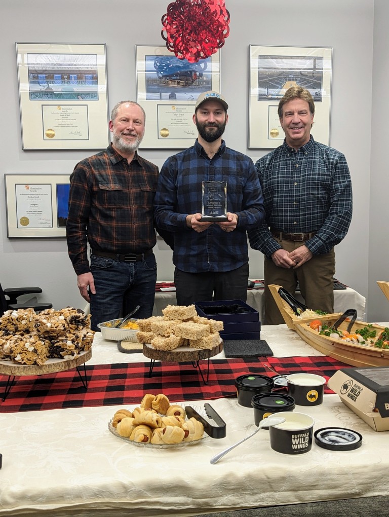 Cory with an award at an event with other AMC employees