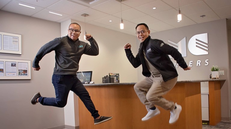 Two AMC employees jumping and smiling