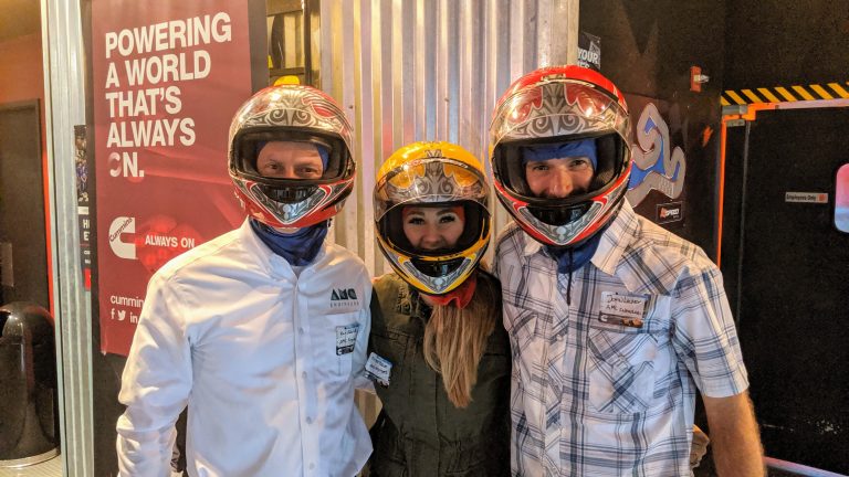 Michelle Pasion and two other AMC employees wearing motorbike helmets