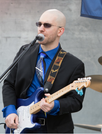 David singing and playing guitar on a stage