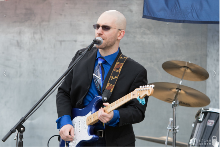 David singing and playing guitar on a stage