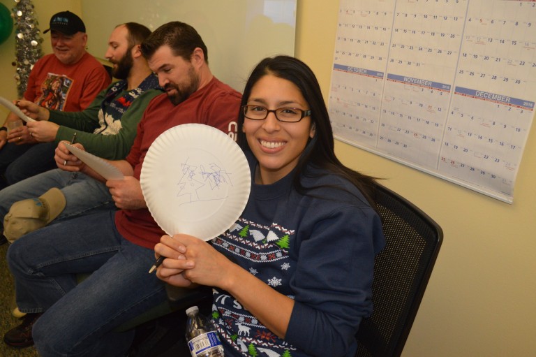 Deborah holding a plate with a drawing at a Christmas party