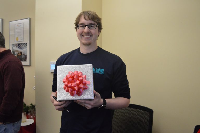 Christian holding a gift box and smling