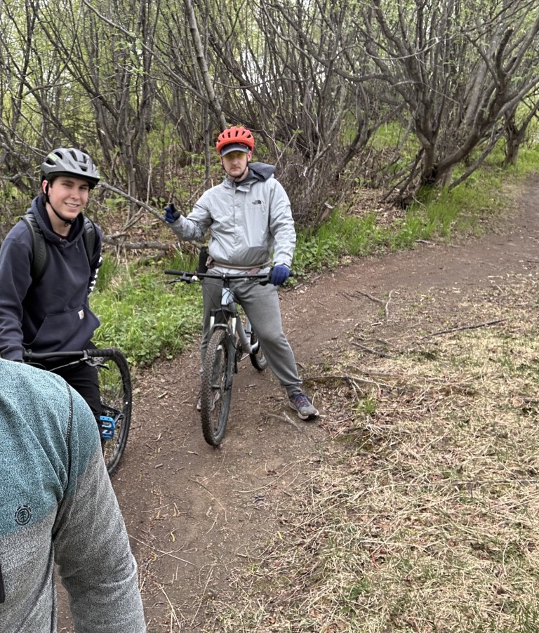 Sam Berdahl biking a trail with a small group