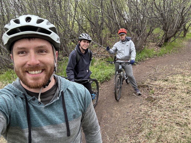 Three AMC employees on a wooded biking trail