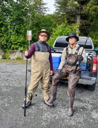 Two people in fishing gear with poles