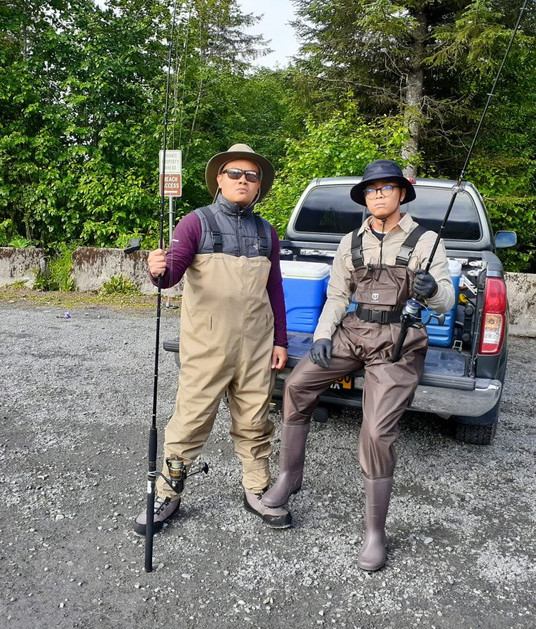 Two people in fishing gear with poles