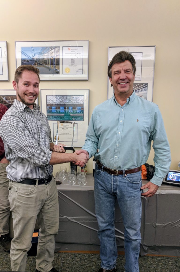 Bart holding an award and shaking hands with another man