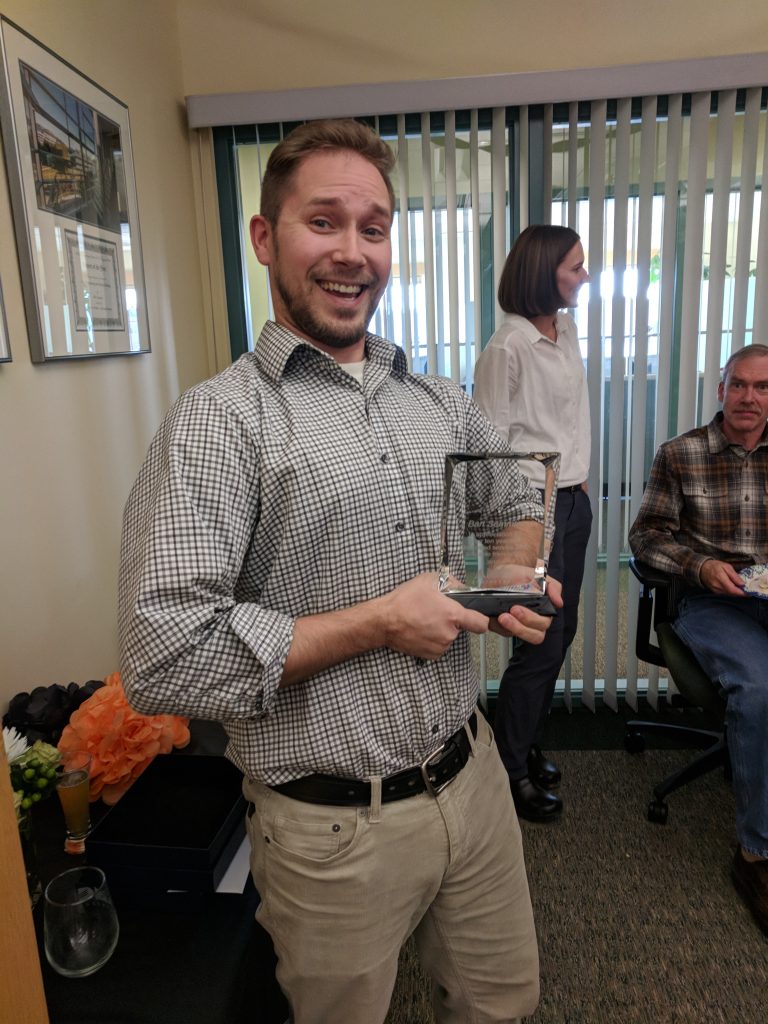 Bart holding an award at a company event