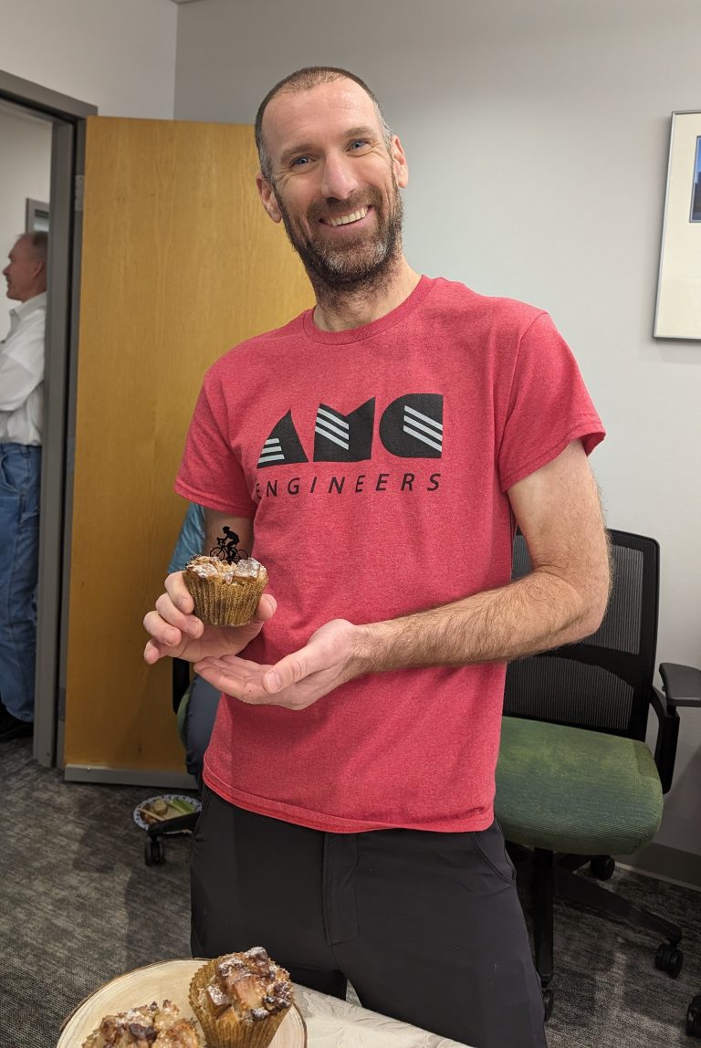 John holding muffin with small biker on it