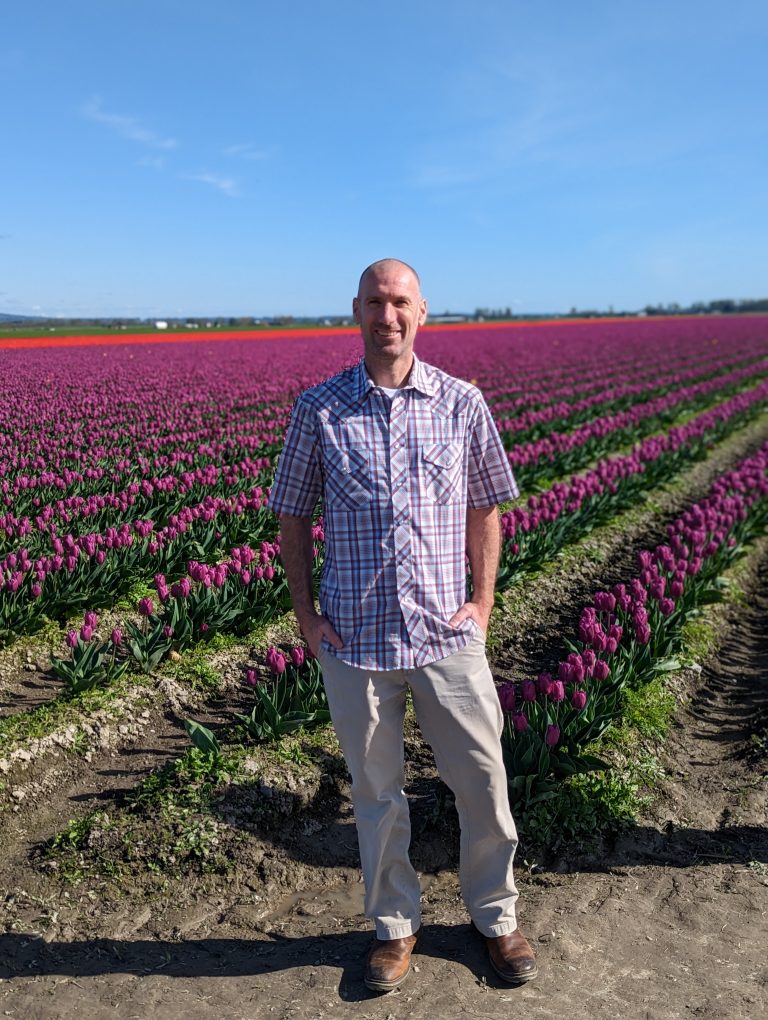 John standing in flower field