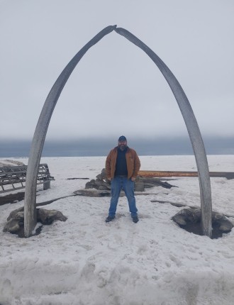 James boggs standing beneath an archway in snowy terrain