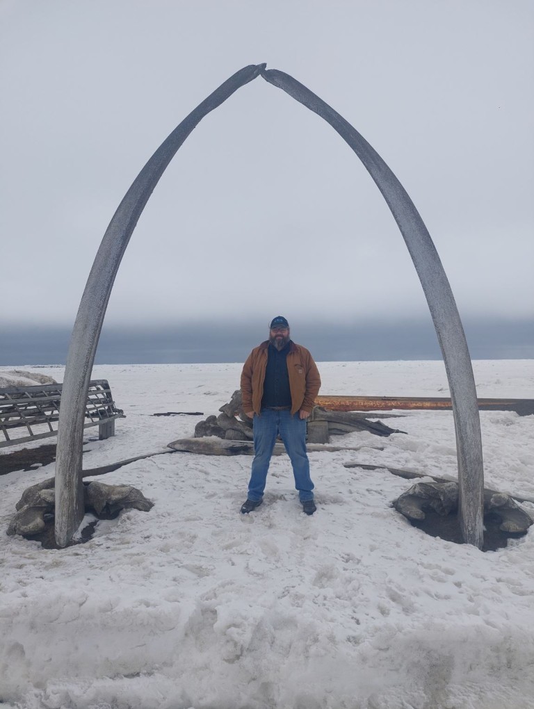 James boggs standing beneath an archway in snowy terrain