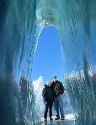 James and a woman standing near an ice cave