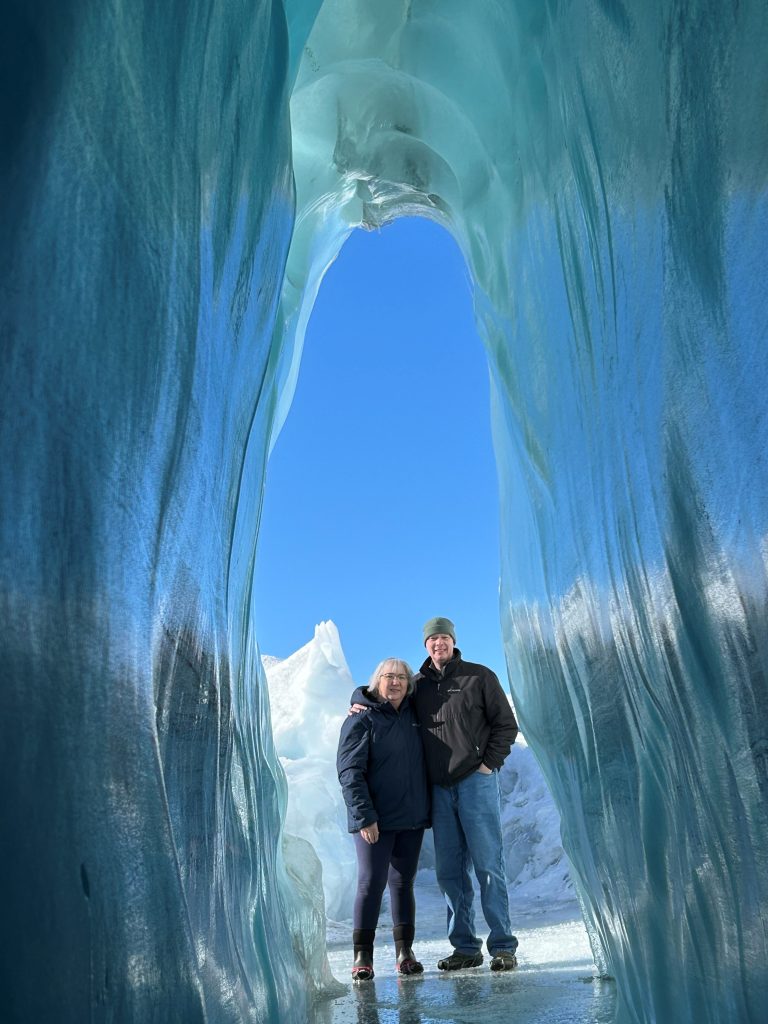 James and a woman standing near an ice cave