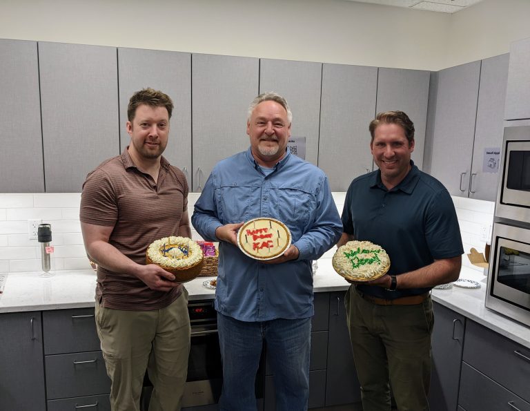 Three AMC employees holding cakes and pies