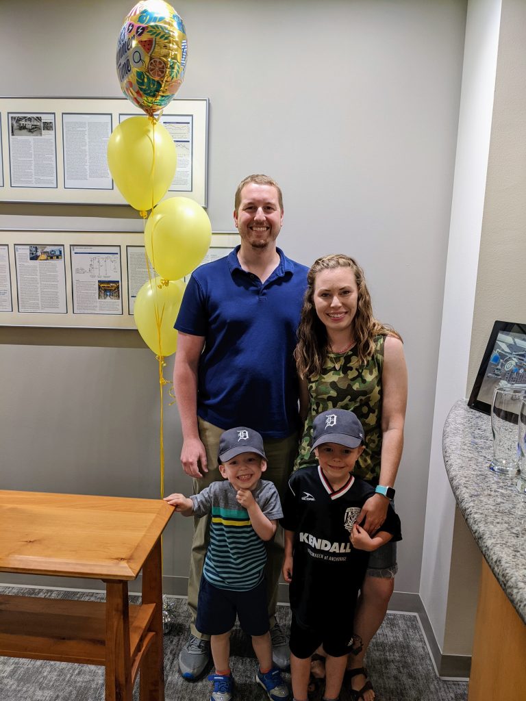 Christian with his wife and two children in the office