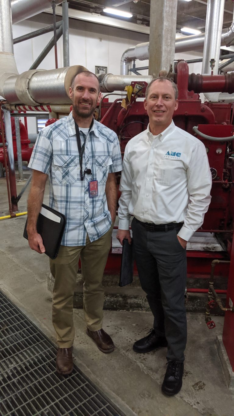 John and Ken Ratcliffe standing in front of large machinery