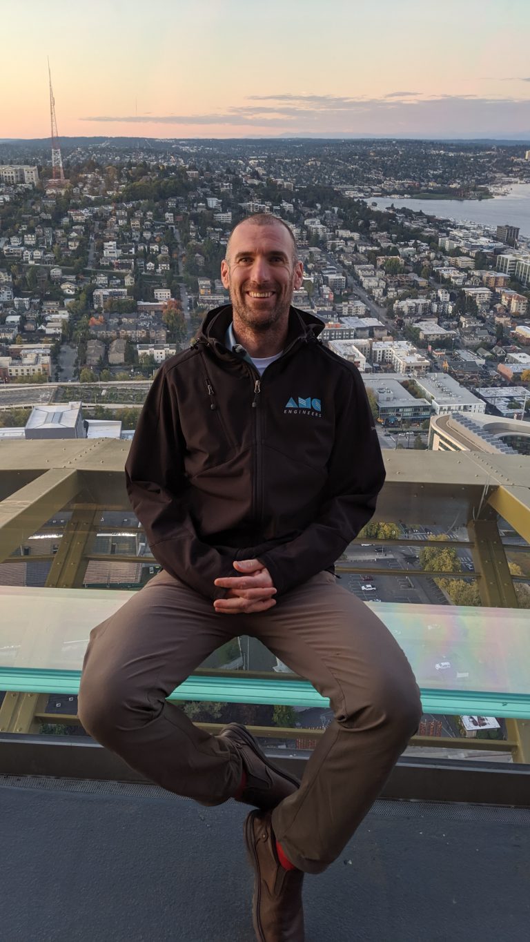 John sitting in the Space Needle with city visible in background