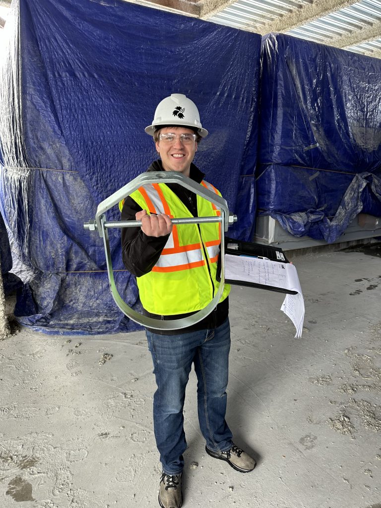 Trenton holding a large piece of machinery