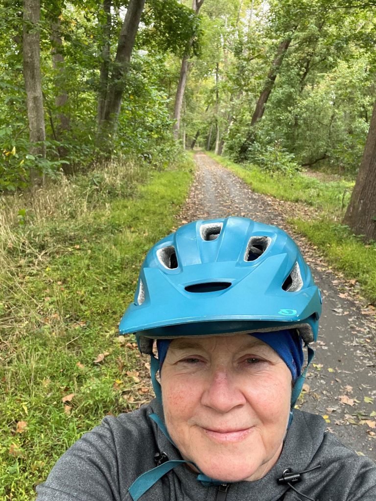 Tami biking on a wooded trail