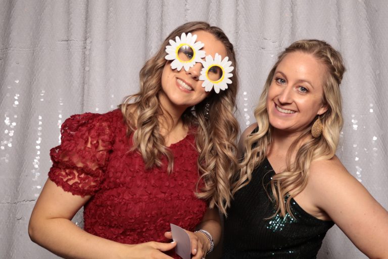 Michelle Pasion and Brittany posing in front of shimmering backdrop