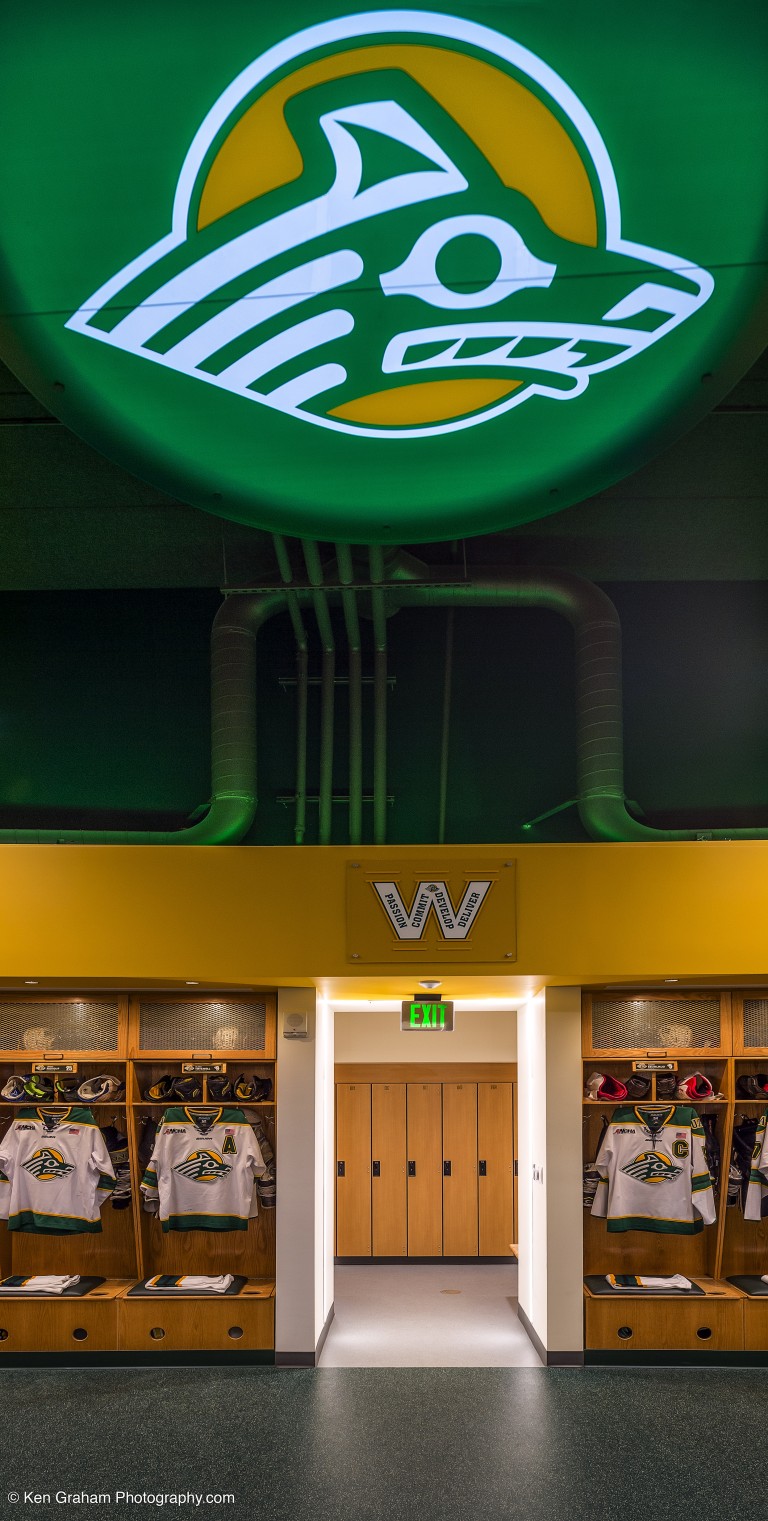 Backlit UAA Logo and visible air ducts on ceiling and wall of locker room