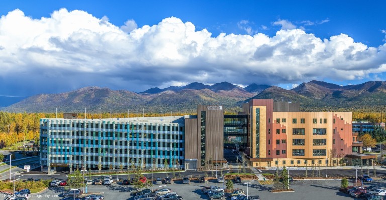 Multistory wood paneled building with attached parking garage