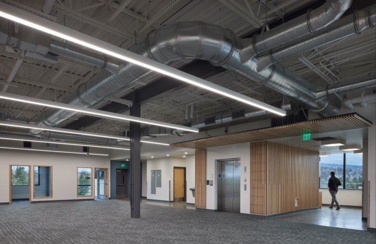 Open office space with modern lighting and visible air ducts