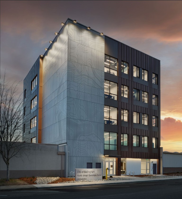 Large 5 story building with topographic engravings and decorative panelling on exterior walls