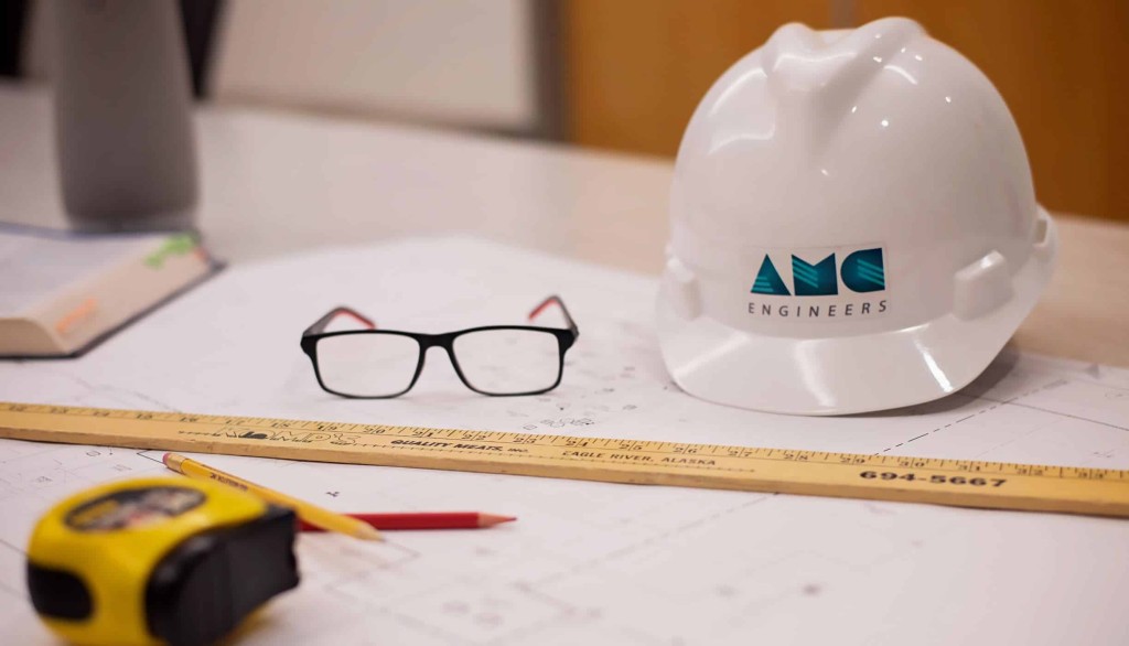 Hard had with AMC logo and tools on table