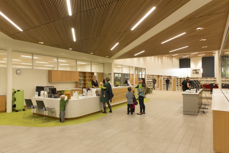 Brightly lit library with wood grated ceilings