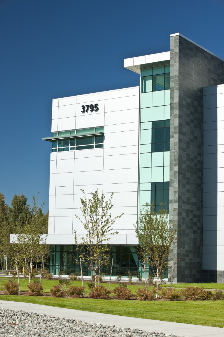 Exterior of multistory building with large glass windows and tiled walls