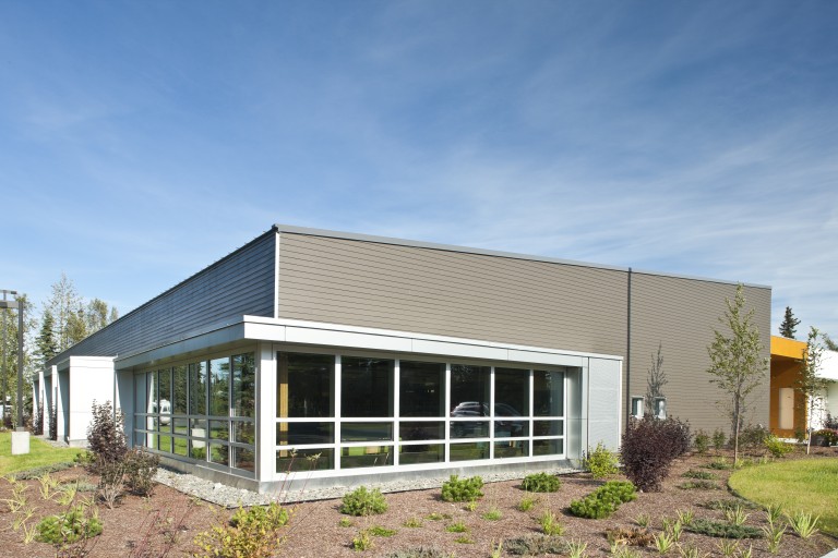 Exterior of one story building with large windows