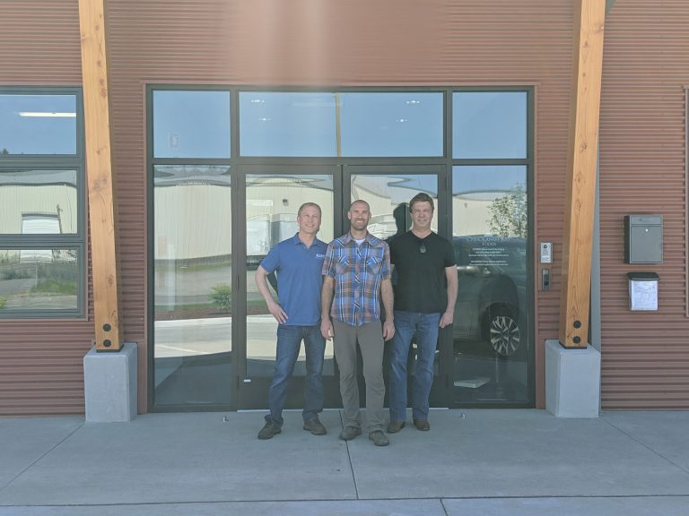 Three AMC employees standing outside of Chuckanut Bay Foods facility