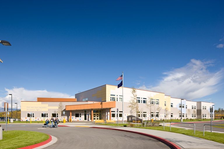 Multi-story school building with colorful tiles and patterns on exterior walls