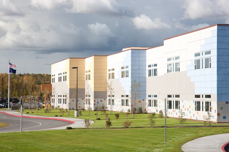 Multi-story school building with colorful tiles and patterns on exterior walls